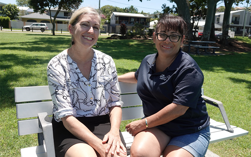 Two women seated on park bench