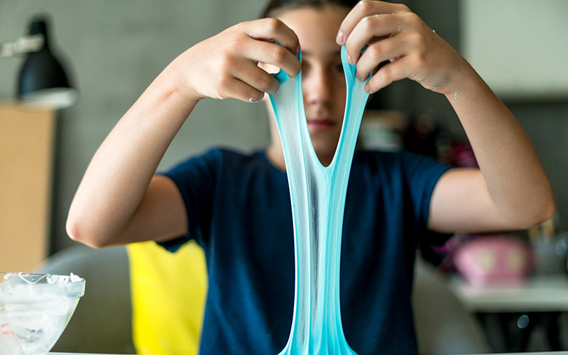 young child playing with blue slime