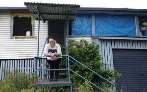 A woman on the staircase of her flood damaged home