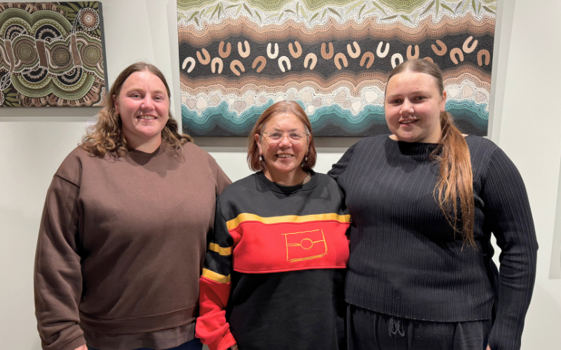 First Nations artists standing in Byron CoLab on Arakwal Country in front of artwork