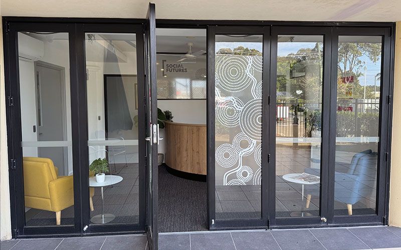 Shows an open glass door with Social Futures Ripple Effect Pattern on it